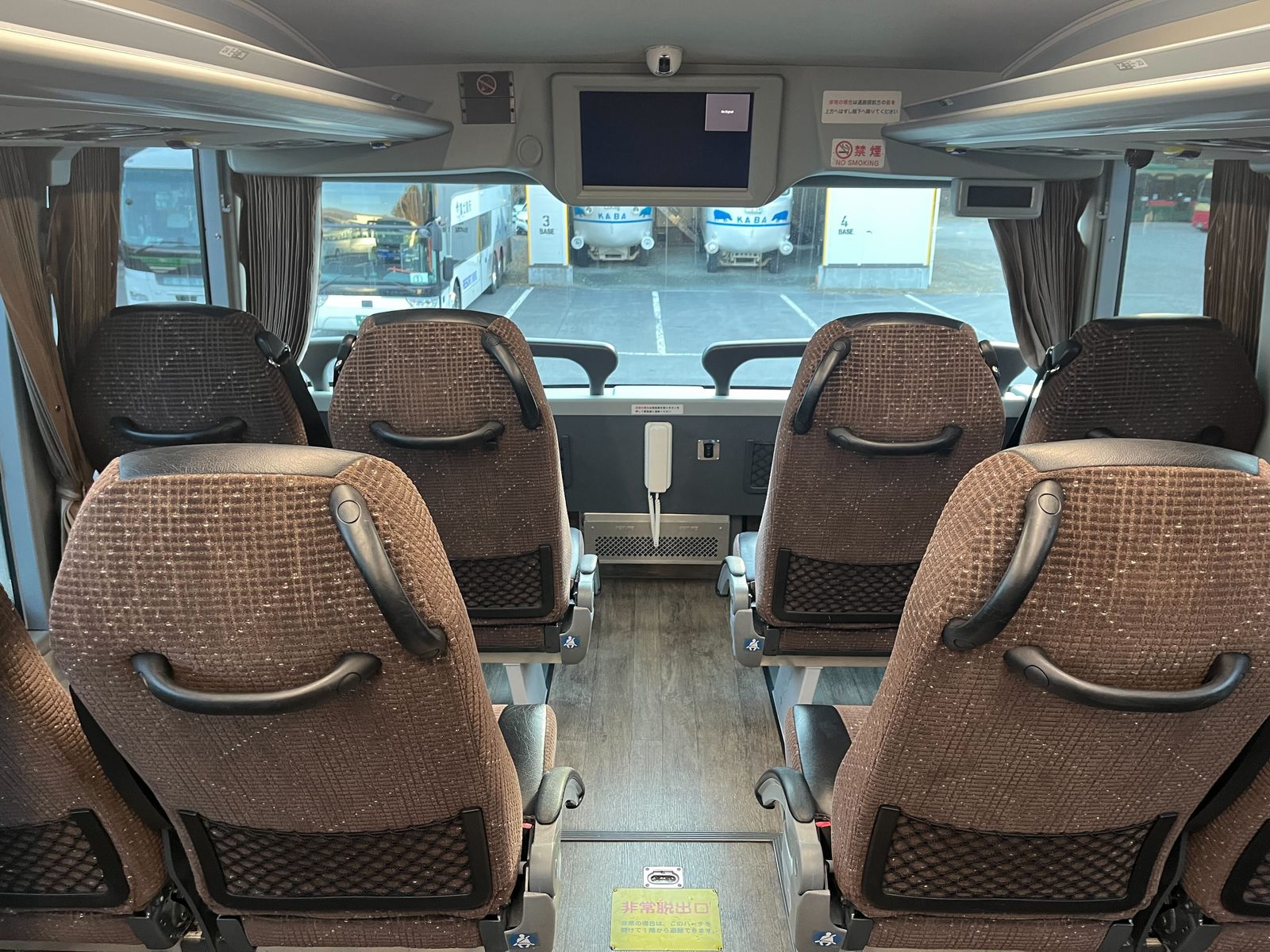 Interior of the Fujikyu highway bus, showing reclining reserved seats and the onboard screen