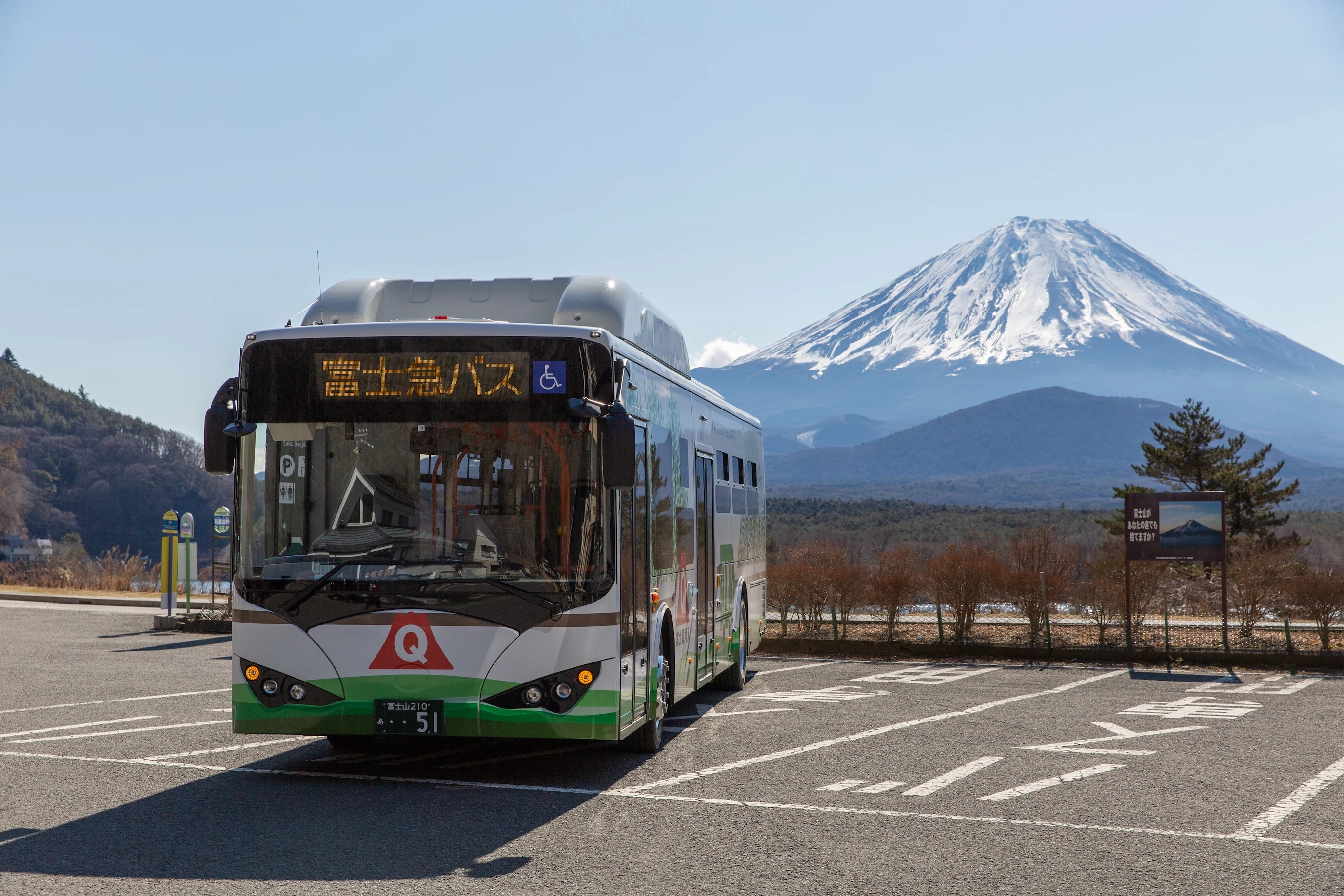 一辆富士急路线巴士停在路边，背景是富士山。